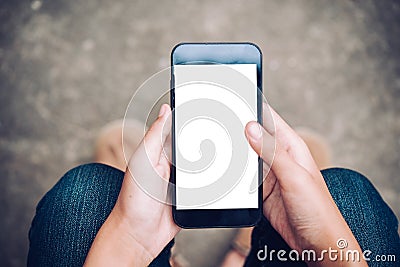 hand holding mobile phone with blank white screen on thigh with Stock Photo