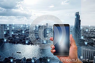 Hand holding mobile phone on blue tone smart city with wifi network connections background Stock Photo