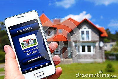 Hand holding mobile phone with house sale offer Stock Photo