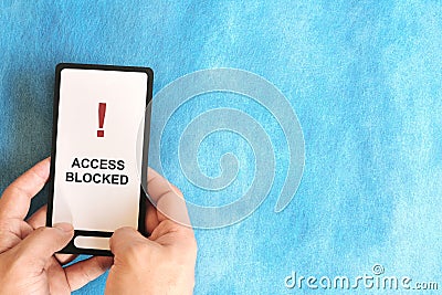 Hand holding a mobile phone with Restricted Site and Website Blocked and Access Denied message display Stock Photo