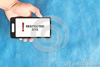 Hand holding a mobile phone with Restricted Site and Website Blocked and Access Denied message display Stock Photo