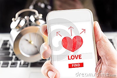 Hand holding mobile with red heart and find love word on screen Stock Photo