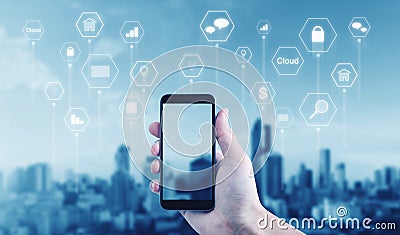 Hand holding mobile smart phone with application icons, city background Stock Photo