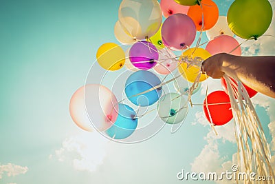 Hand holding multi colored balloons Stock Photo