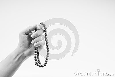 Hand holding a muslim rosary beads or Tasbih on black and white. Stock Photo