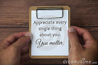 Hand holding paper holding board with text - Appreciate every single thing about you. You matter. Inspirational and Stock Photo