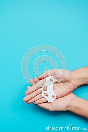 Hand holding paper Car cutout on blue background. Vehicle insurance, warranty, Automobile rental, Transportation, Maintenance and Stock Photo