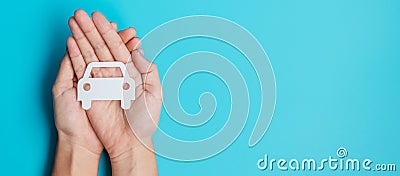 Hand holding paper Car cutout on blue background. Vehicle insurance, warranty, Automobile rental, Transportation, Maintenance and Stock Photo