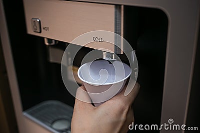 A hand holding a paper glass for water Stock Photo