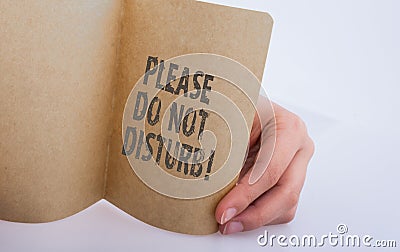 Hand holding a paper with Please do not disturb label Stock Photo