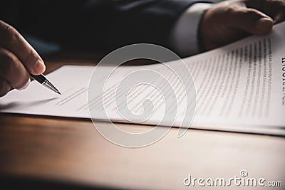 Hand holding pen signing contract in important documents. Stock Photo