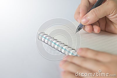 Hand holding pen writing notebook Stock Photo
