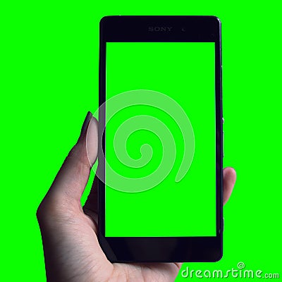 Hand holding phone with green background Stock Photo