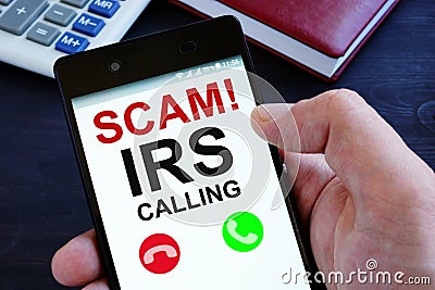 Hand is holding phone with irs scam calls Stock Photo