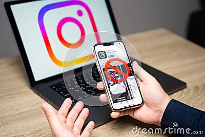 Hand holding a phone with Threads Instagram app and ban sign in the screen. The ban of the social network by the authorities of Editorial Stock Photo