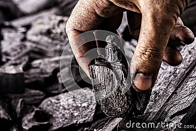 hand holding piece of charcoal, with background. Dirty coal emitter hand, MACRO PHOTOGRAPHY Stock Photo