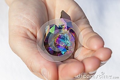 Hand holding a piece of Rainbow titanium aura Stock Photo