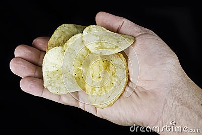 Hand holding potato chips Stock Photo