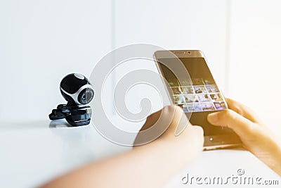 Hand holding and press mobile connect security camera,Phone watch CCTV Stock Photo