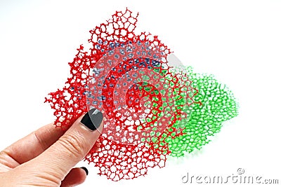 Hand holding red coral lace crepe decorative elements for food plating Stock Photo