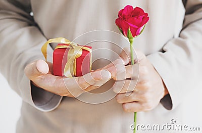 Hand holding red gift box, with rose flower, vintage tone Stock Photo