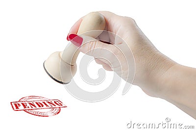 Hand holding a rubber stamp with the word pending Stock Photo