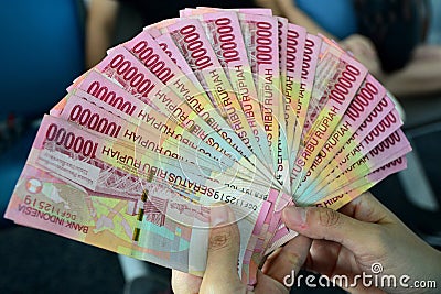Hand holding rupiah Indonesian money Stock Photo