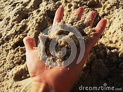 Hand holding sand on a beach Stock Photo