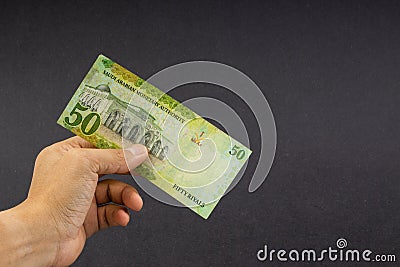 Hand holding saudi riyal bank notes on black background. Stock Photo