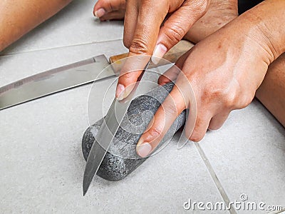 Hand holding sharpen knife and whetstone Stock Photo