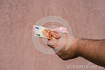 Hand holding showing euro money and giving or receiving money like tips, salary. 10 EURO banknotes EUR currency . Concept Stock Photo