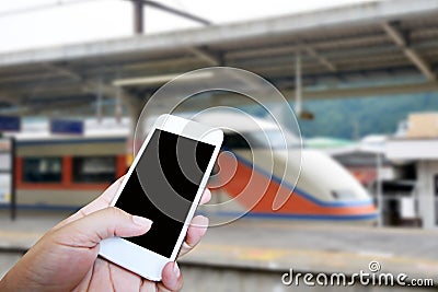 Hand holding smart phone over blur train station background Stock Photo