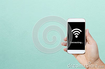 Hand holding smart phone / white mobile phone with wifi connect on black screen. Stock Photo