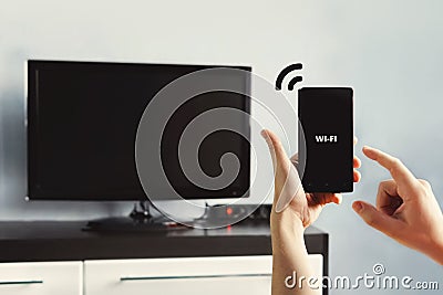 hand holding a smartphone against view of living room Stock Photo