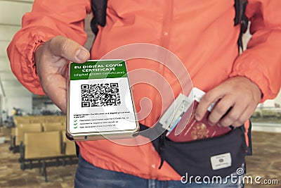 Hand holding smartphone display on app mobile vaccinated covid-19 or covi-pass certificate, immunity vaccine passport, at airport Editorial Stock Photo