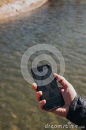 Hand holding smartphone with radiation icon Stock Photo