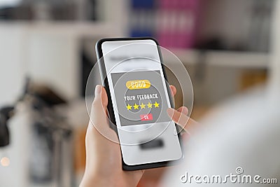 Hand holding smartphone and rate your feedback and show five star on application. Stock Photo