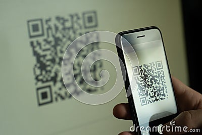 Hand holding smartphone, scanning qr code with smartphone Stock Photo