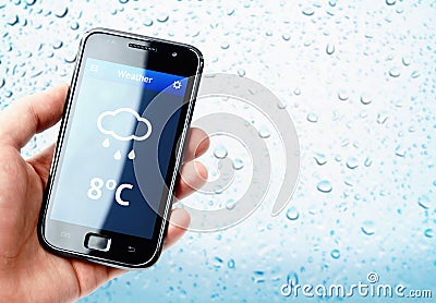 Hand holding smartphone with weather with rainy window Stock Photo