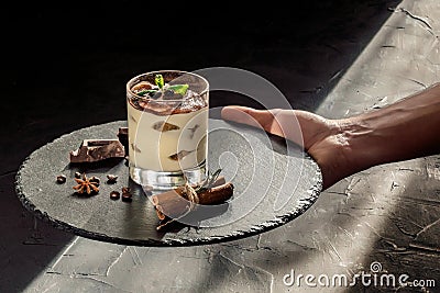 Hand holding a sweet tiramisu with cacao powder Stock Photo