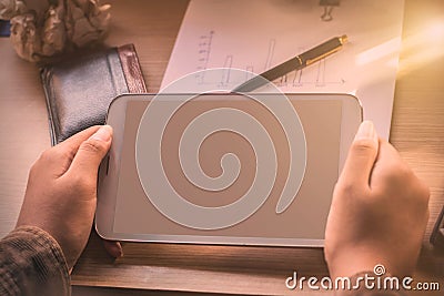 Hand of holding tablet on desk Stock Photo