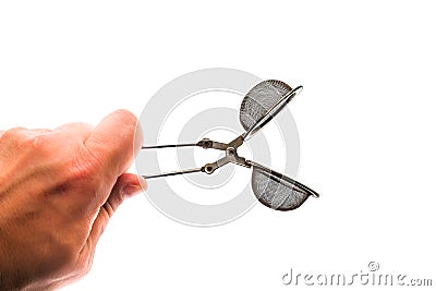 Hand holding tea strainer clamp on the white background. Stock Photo