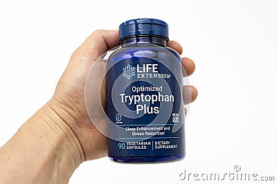 Hand Holding Tryptophan Plus Optimized by Life Extension with 90 Vegetarian Capsules. Isolated on White Background Editorial Stock Photo