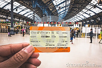 Hand holding a UK train ticket at Brighton & Hove train station for background in Brighton, England. Editorial Stock Photo