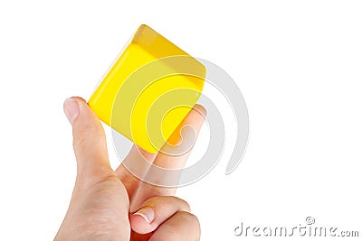 Hand holding up a simple plain yellow floating hovering cube element or node grabbing it between fingers, isolated. Network app Stock Photo