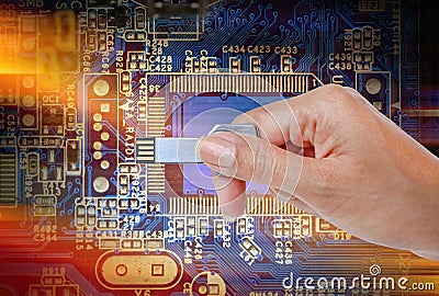 Hand holding USB data storage against bright light and circuit Stock Photo