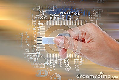 Hand holding USB data storage against bright light and circuit Stock Photo