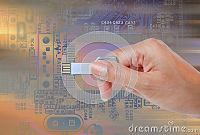 Hand holding USB data storage against bright light and circuit Stock Photo