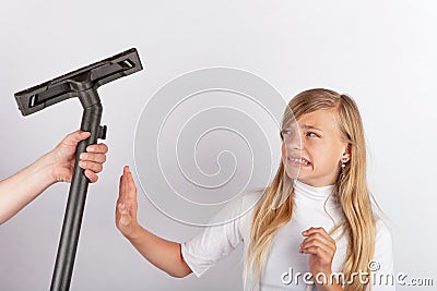 Hand holding a vacuum tube but the girl refusing housework. Stock Photo