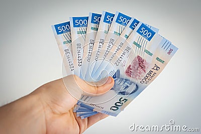 Hand holding various mexican pesos of 500 Stock Photo